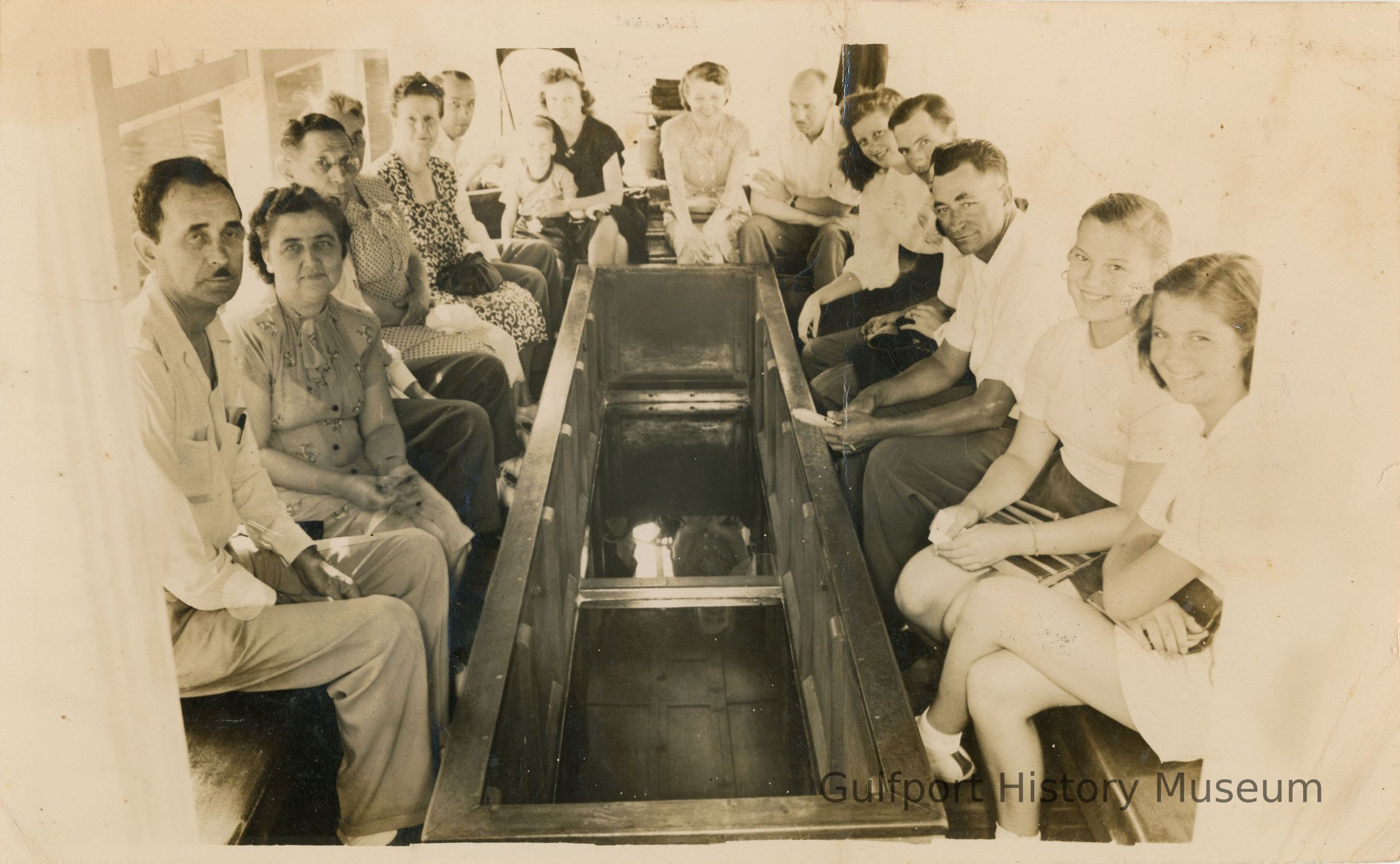 A black and white photograph of a group of people on a boat.