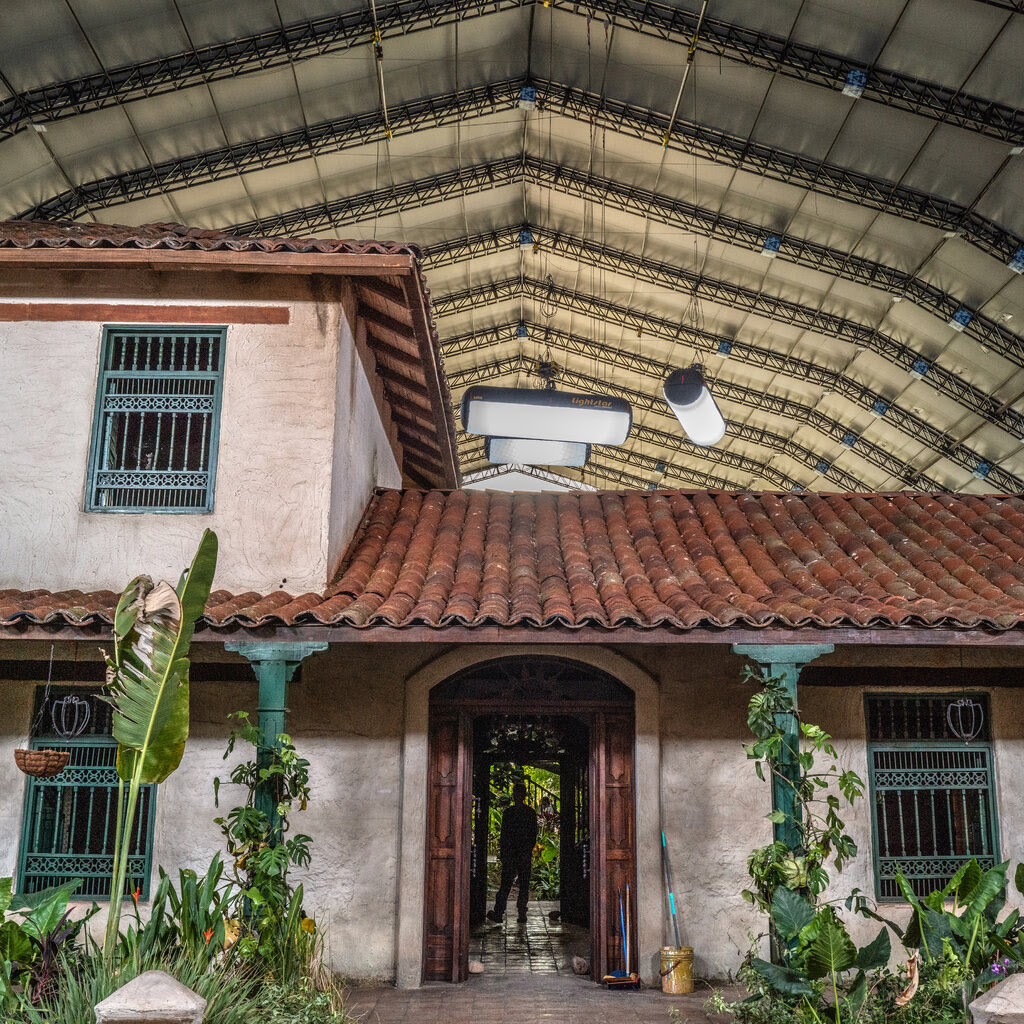 A house with a garden and is shown under an enormous hangar. 