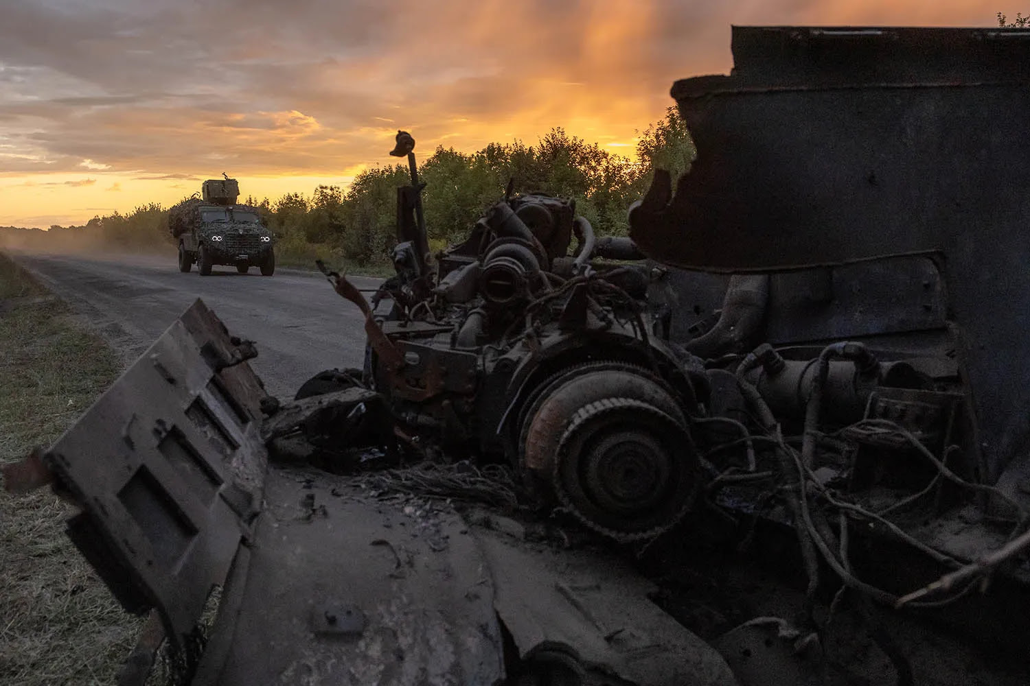 A Ukrainian military vehicle drives past the remains of another in the Sumy region, Ukraine, amid the Ukrainian incursion into neighboring Kursk, Russia, on Aug. 13.