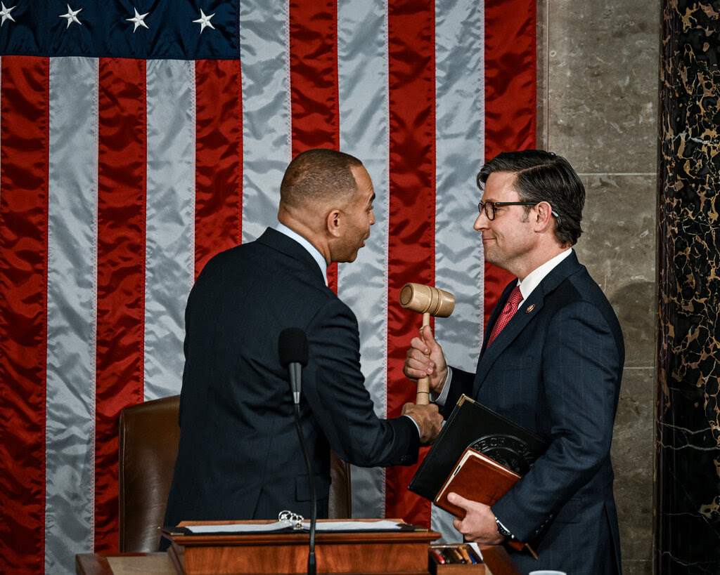 Hakeem Jeffries passes a gavel to Speaker Mike Johnson. 