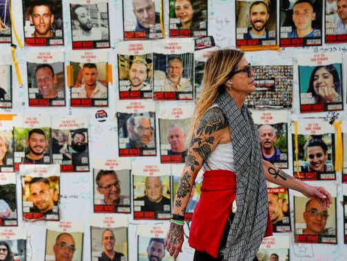 A woman walks past pictures of hostages in Tel Aviv, Israel, in February.