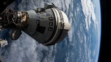 Boeing Starliner Spacecraft Docked to the Harmony Module From a Window on the SpaceX Dragon Endeavour