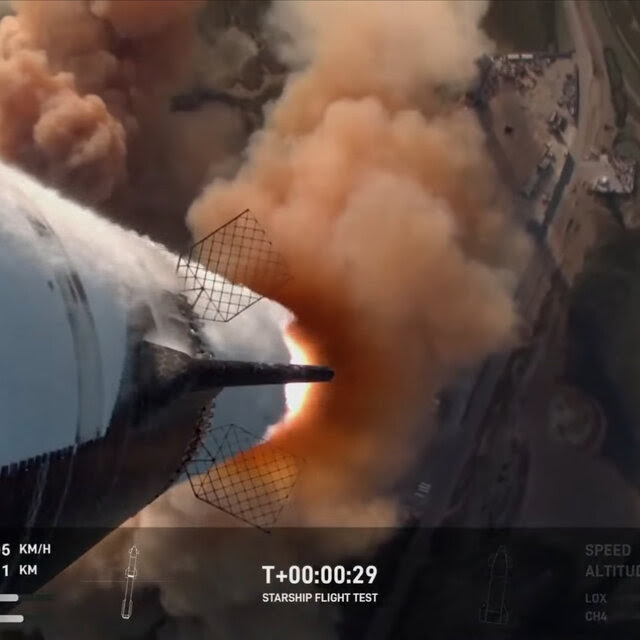 A view looking down the rocket as it is 29 seconds into its launch from the launchpad.