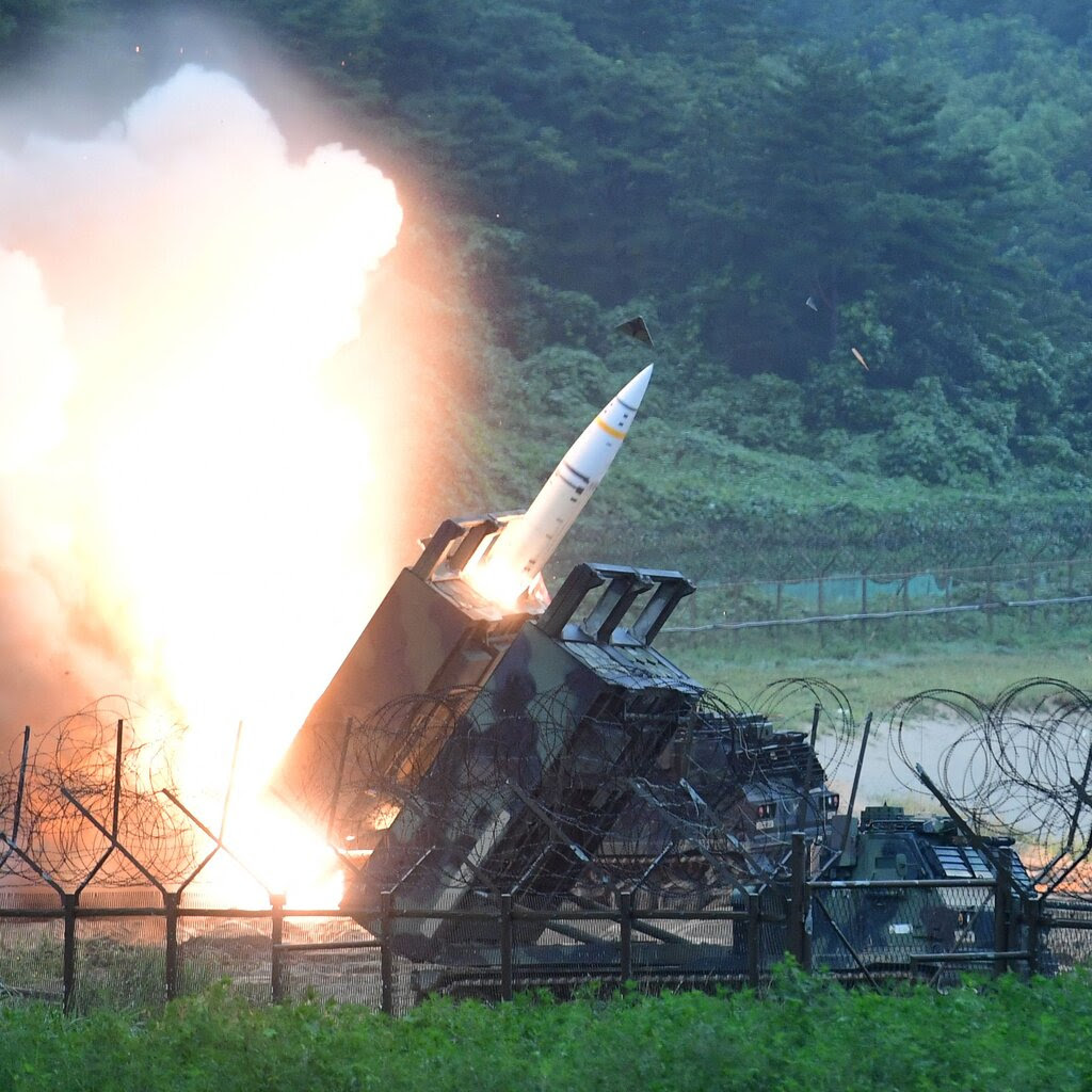 A missile being fired from a missile launcher, with a cloud of fire.