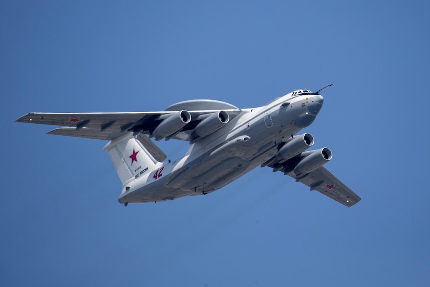 A Beriev A-50 military airplane flies upward against a blue sky