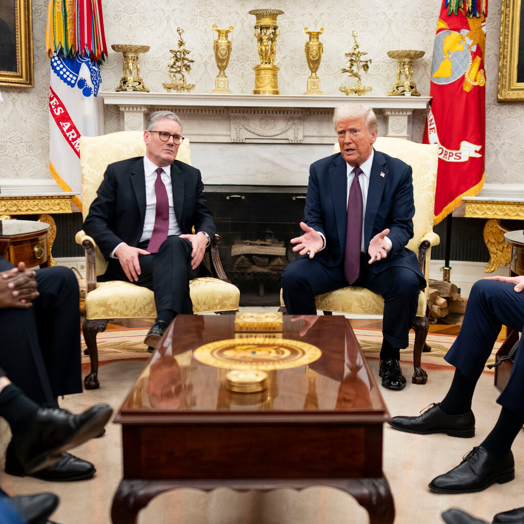 Donald Trump sitting in a chair next to Keir Starmer in the oval office.