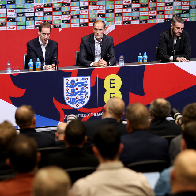 Thomas Tuchel, in a navy suit and white shirt, speaking to journalists at a news conference on Wednesday.