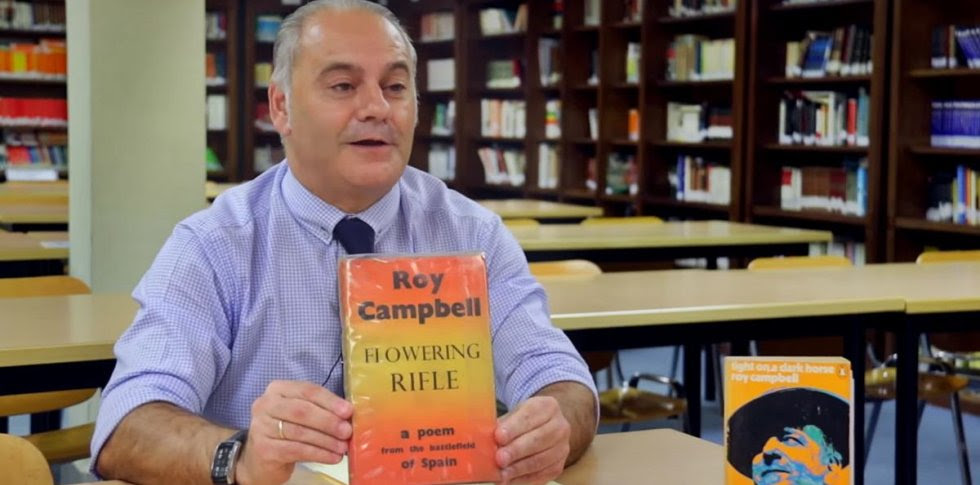 Emilio Domínguez Díaz muestra un libro de Roy Campbell.