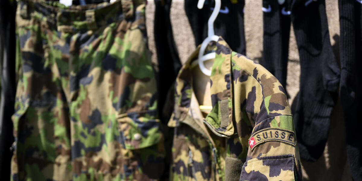 La tenue de combat de camouflage, tenue C, du systeme modulaire d'habillement et d'équipement pour les engagements militaires de l' Armee Suisse seche au milieu de la lessive sur un etendage ce samedi 20 juillet 2024 a Daillens. (KEYSTONE/Laurent Gillieron)