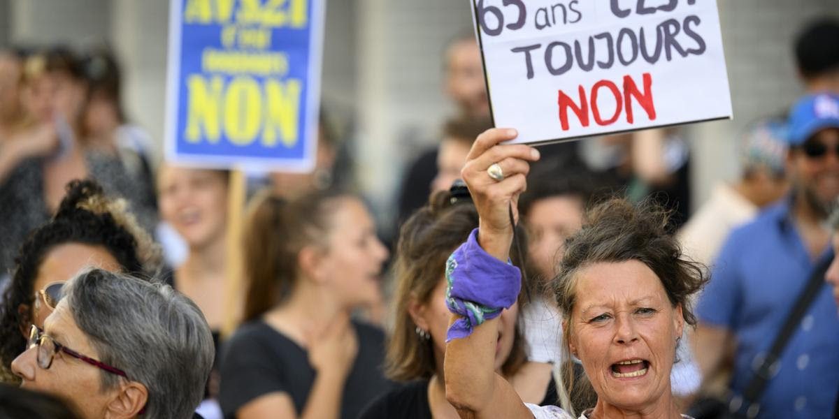 Des personnes brandissent des pancartes lors d'une manifestation contre AVS 21 et contre l?augmentation de la TVA en marge d'une conference d'Alain Berset sur AVS21 ce lundi 5 septembre 2022 devant le Musee Cantonal des Beaux-Arts, MCBA, a Lausanne. Les manifestants ont critique ce projet de reforme de l'Assurance-vieillesse et survivants (AVS) soumis a votation federale le 25 septembre. (KEYSTONE/Laurent Gillieron)