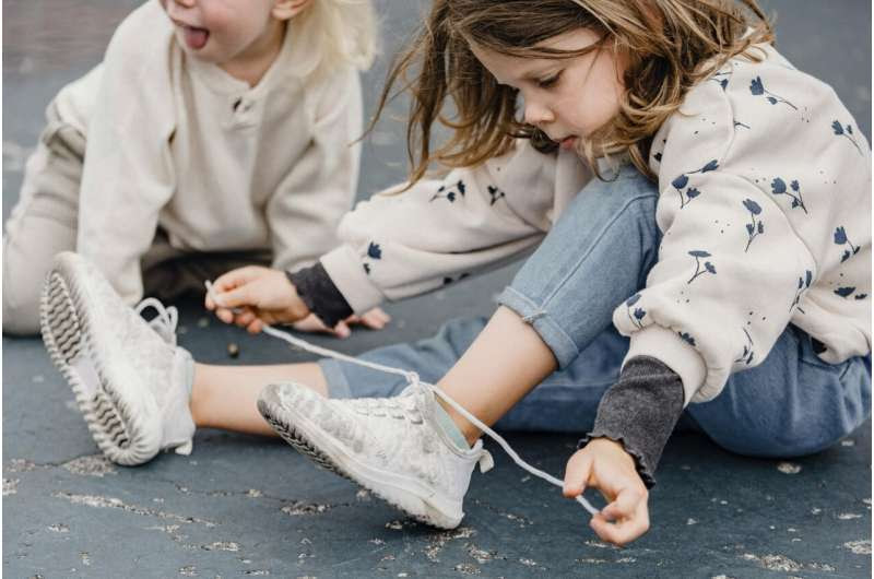 child tying shoe