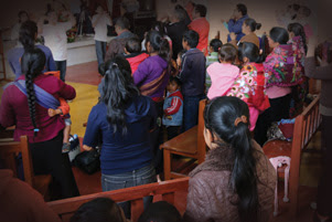 A congregation in Mexico is standing together.