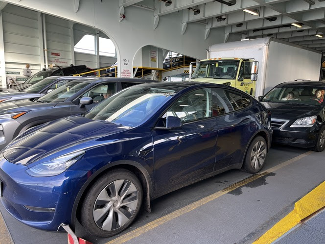 Several vehicles parked inside the car deck of a ferry