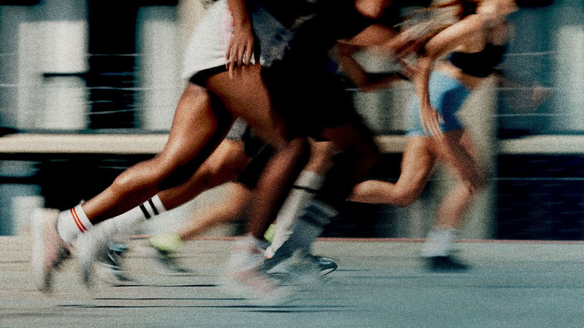 Runners' legs in motion, in front of a building.