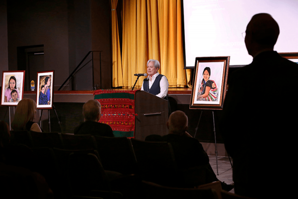 Sister Norma Pimentel talks about her ministry while standing near some of her paintings of migrants