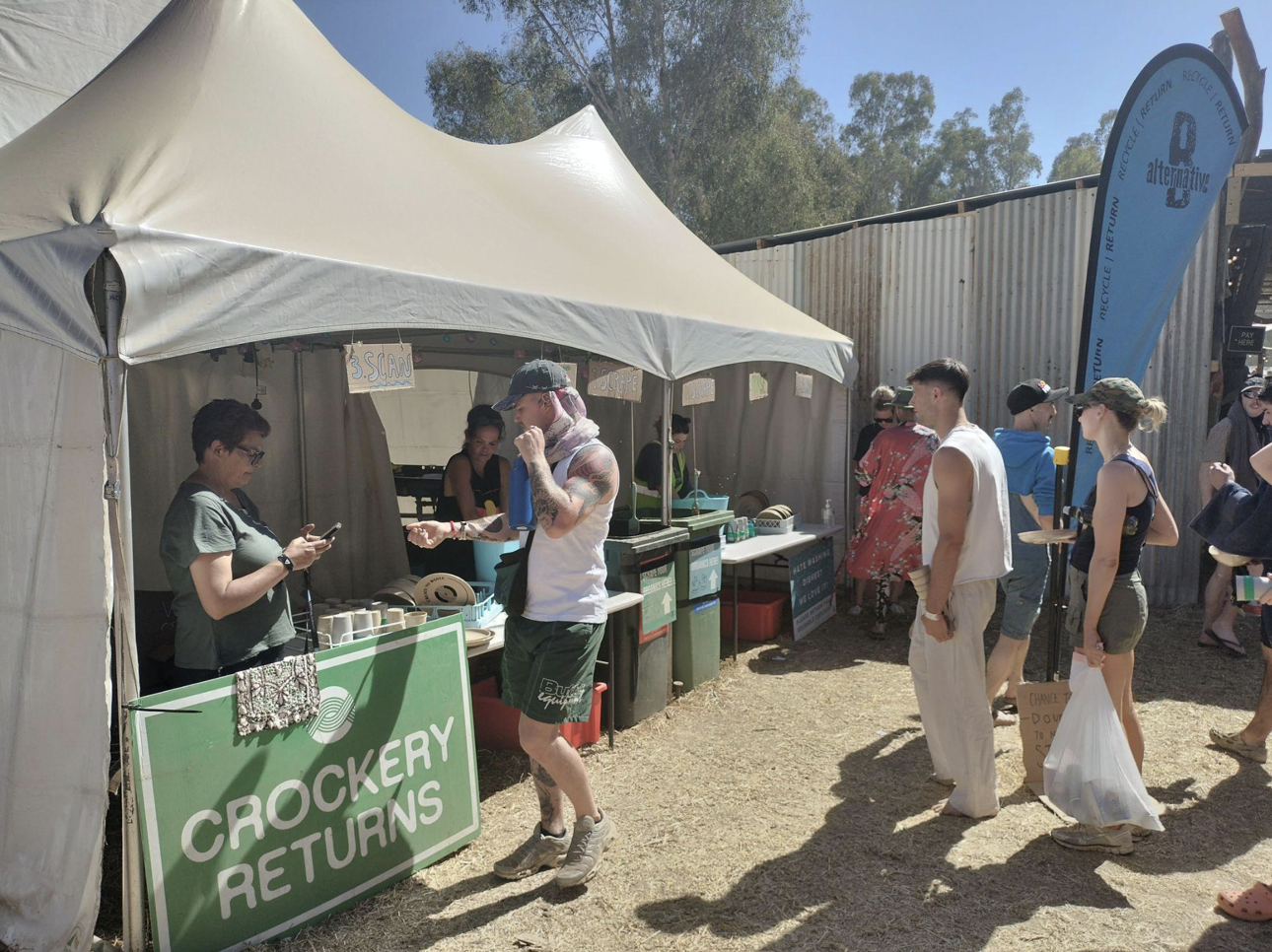 Festival attendees lined up at tents for reusable crockery returns.