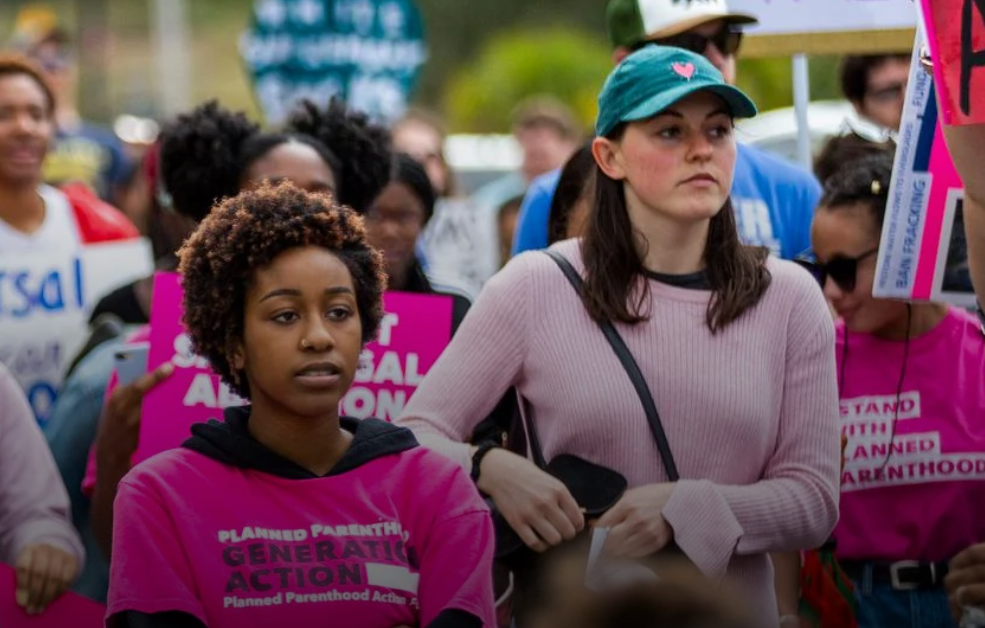 People in pink march through the streets with Planned Parenthood gear