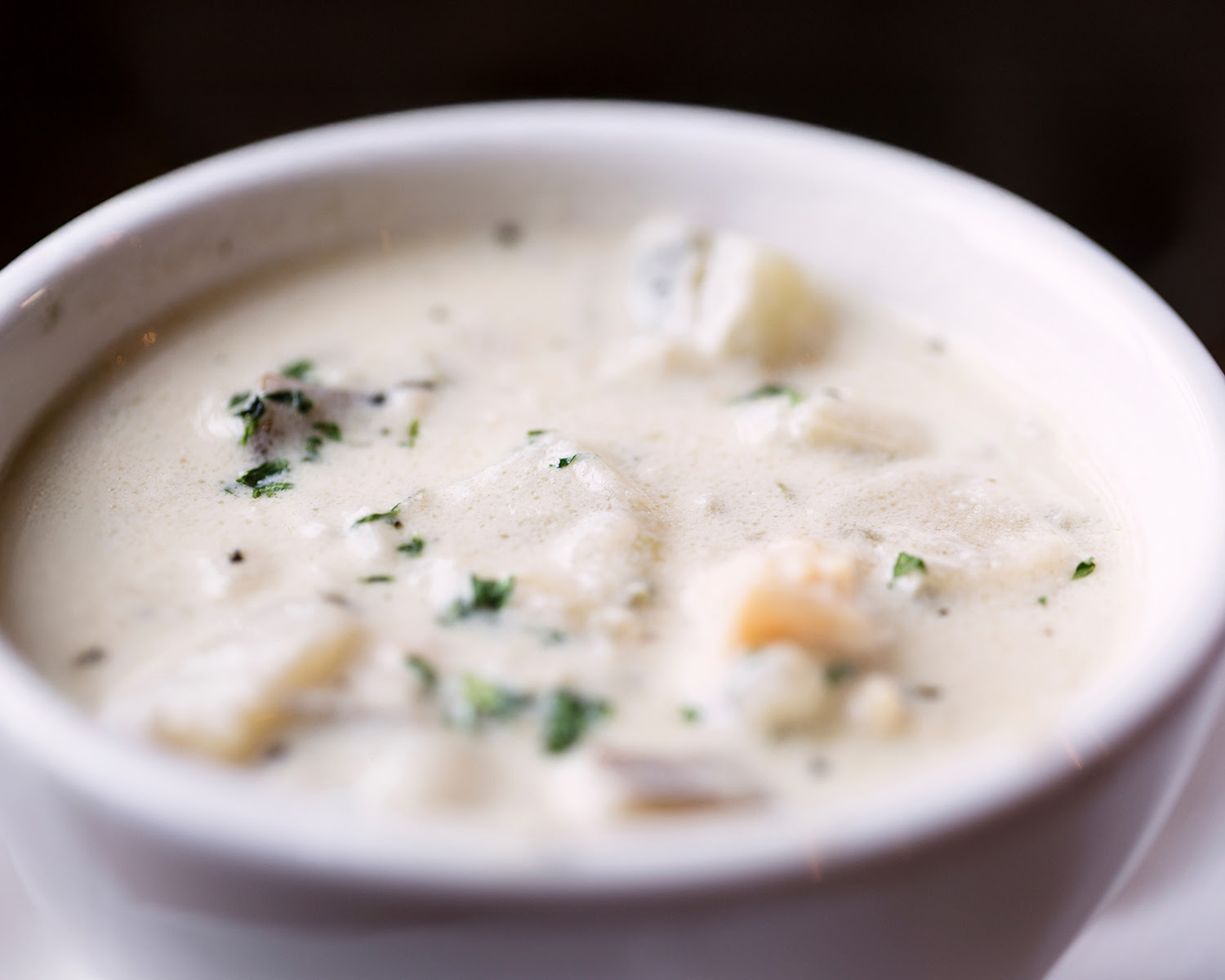 A close up of a warm bowl of clam chowder.
