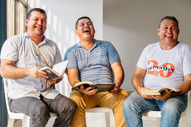 Three men sitting and laughing