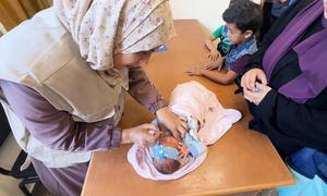 Un bebé recibe la vacuna de la polio en una clínica de la UNRWA en el campamento de Al-Nuseirat, en el centro de la Franja de Gaza.