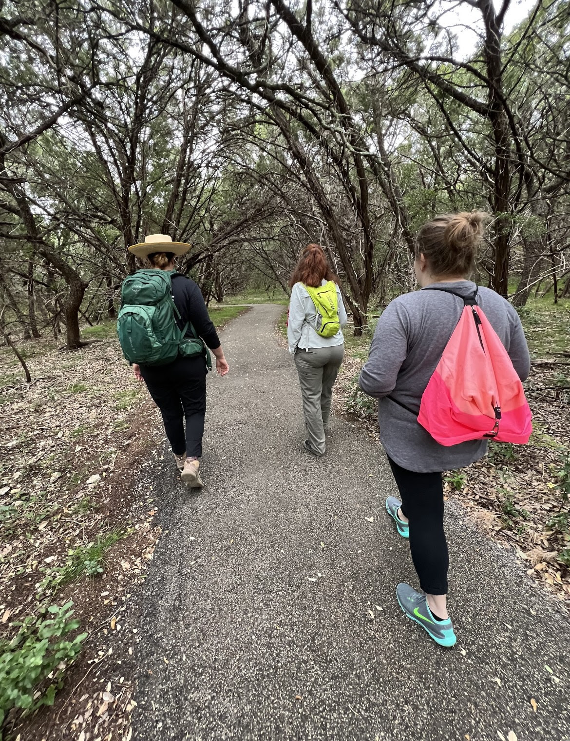 Pictured: Three women walking alongside a nature trail surrounded by trees in the fall. Picture credits to Sierra Club Military Outdoors 