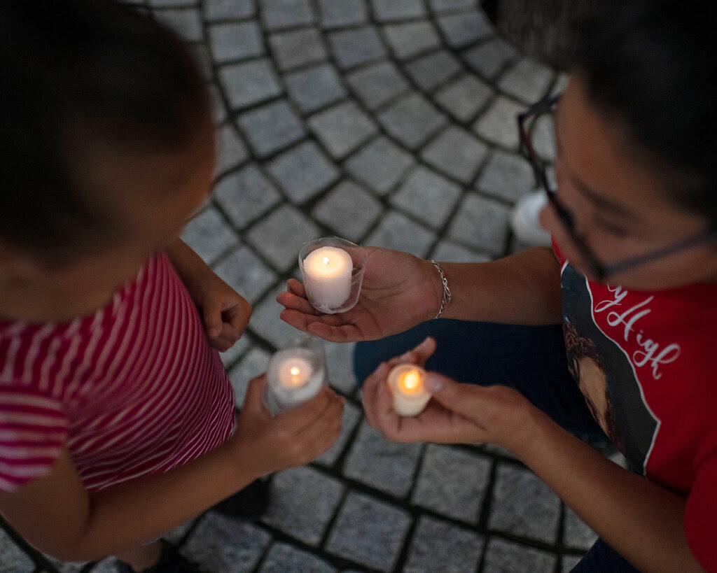 An image of a woman and a child holding candles, taken from above. 