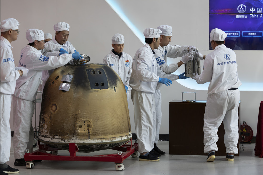 Researchers prepare to weigh Chang'e 6 lunar samples stored in a sealed container.
