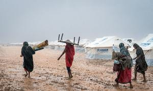 Mujeres desplazadas tratan de poner a salvo sus pertenencias durante las inundaciones en Kassala, Sudán.