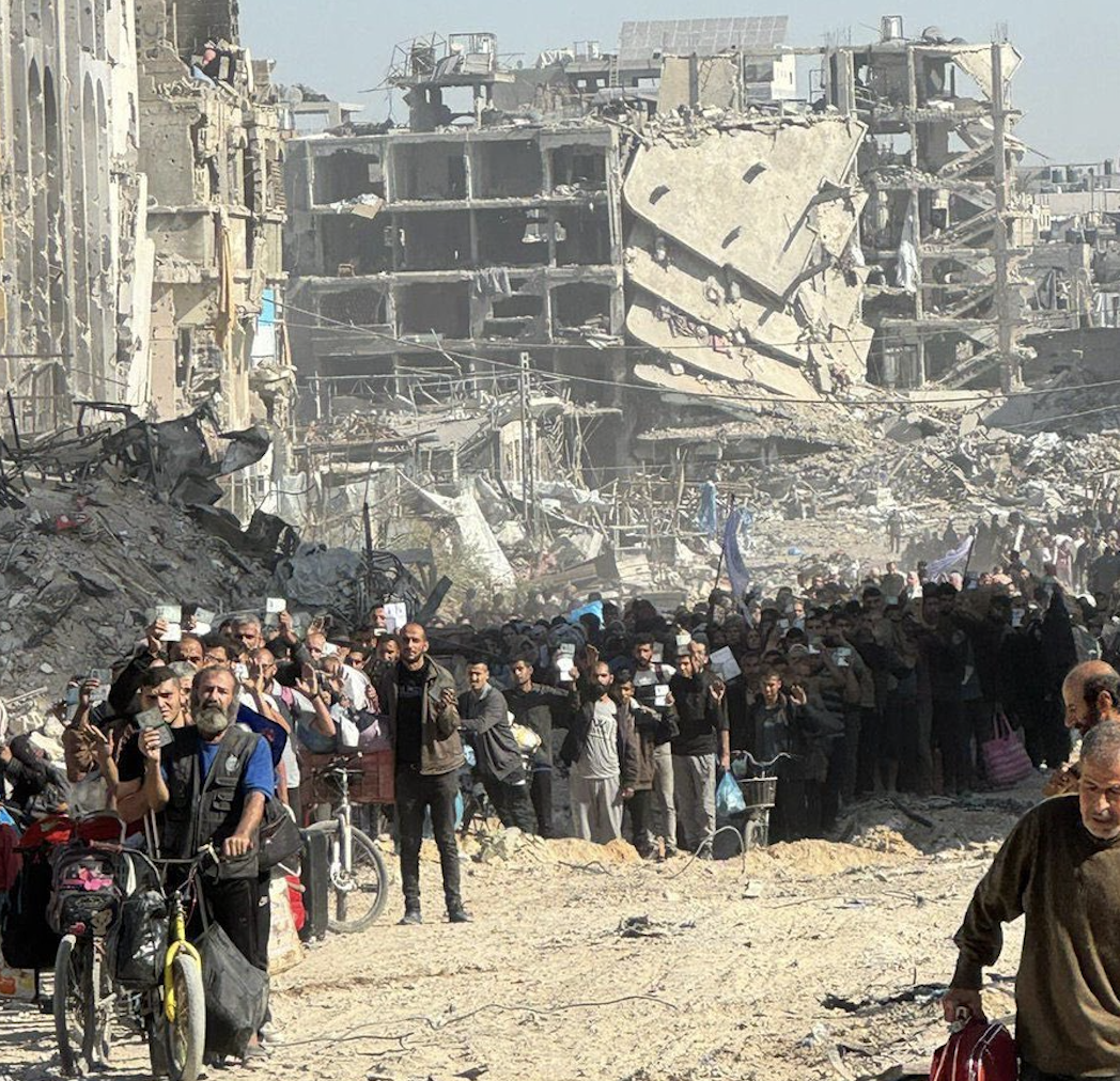 Displaced Palestinians line up at gunpoint in the ruins of Jabalia refugee camp. (Used in accordance with Clause 27a of the Copyright Law)