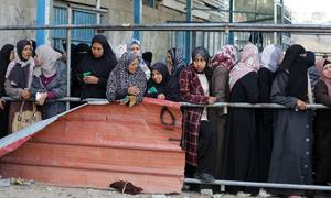 Mujeres de Gaza hacen cola en un punto de distribución de alimentos.