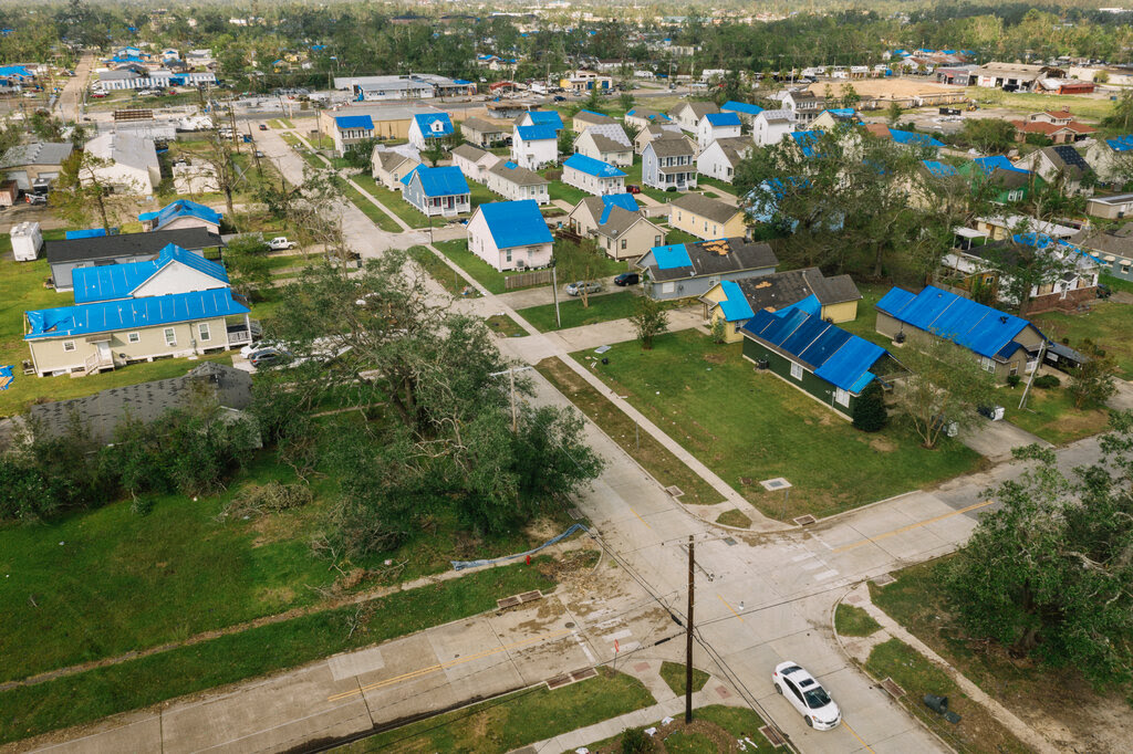An aerial view of houses, many of which have blue roofs.