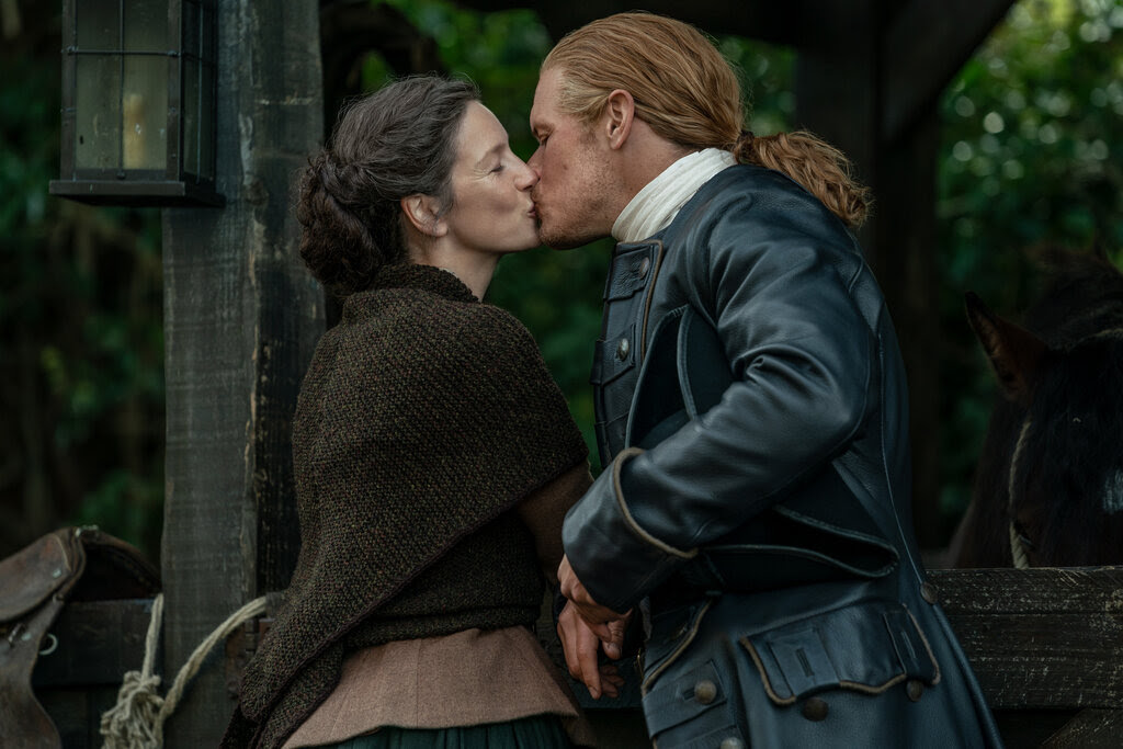 A woman and a man in period garb grab a smooch.