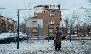 Una mujer delante de su casa dañada por las bombas en Kharkiv, Ucrania.