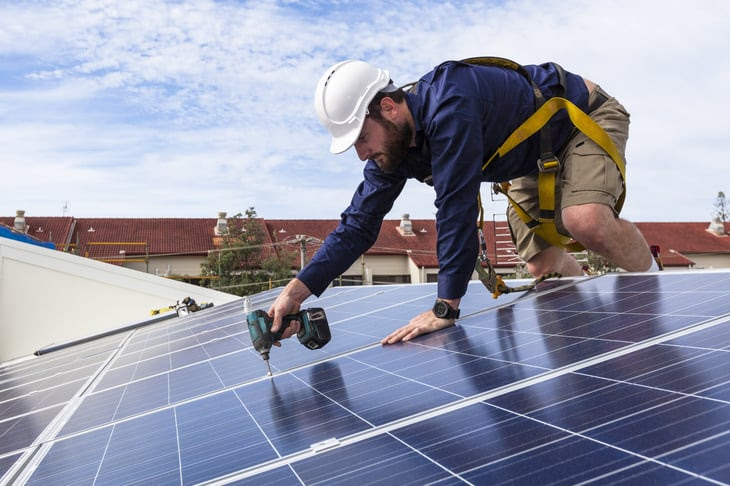 Worker installing solar panels