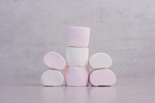 Sweet white marshmallows on white table.