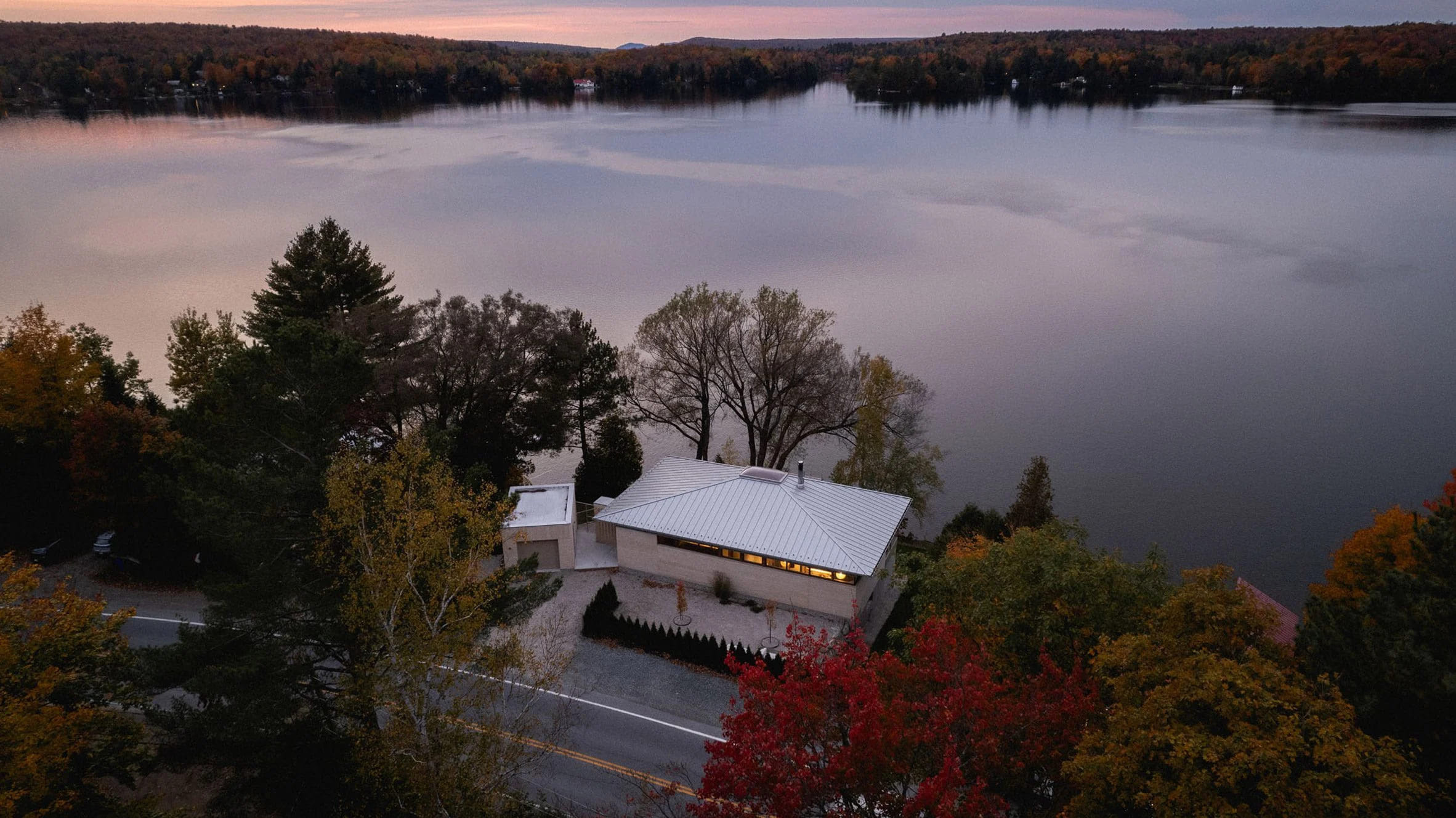 La vivienda, bautizada como Palissade y diseñada por Naturehumaine, se ubica entre una carretera y un lago en Quebec.