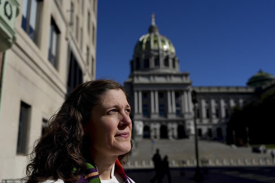 Rev. Anna Layman Knox, a woman with light skin and brown hair, poses for a photo in front of the Pennsylvania State Capitol building.