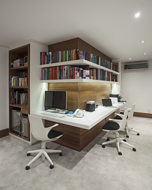 Nesse projeto do Korman Arquitetos, o corredor se transformou em home office. Para acompanhar a angulação da parede, estantes, prateleiras e uma mesa projetada sob medida fazem do espaço algo totalmente funcional | Projeto da Korman Arquitetos | Foto: Gui Morelli