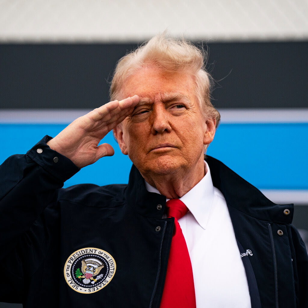 President Trump with his right hand raised to his forehead in salute. 