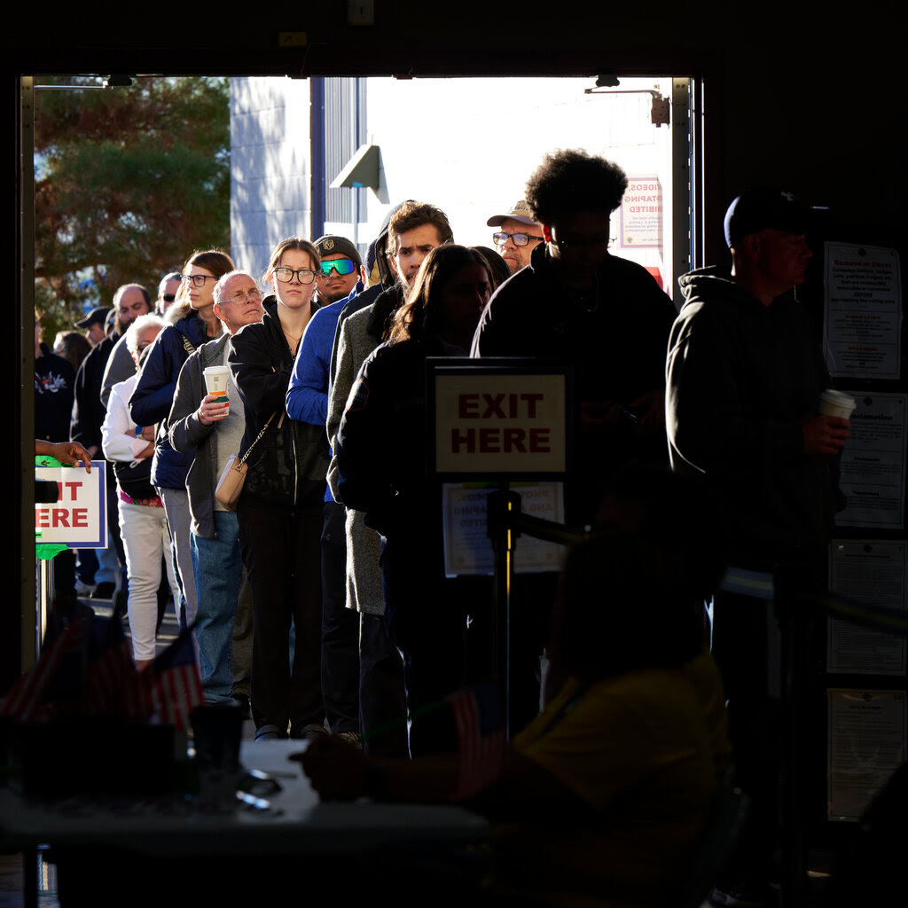 A line of voters stretching from inside to outside a building.