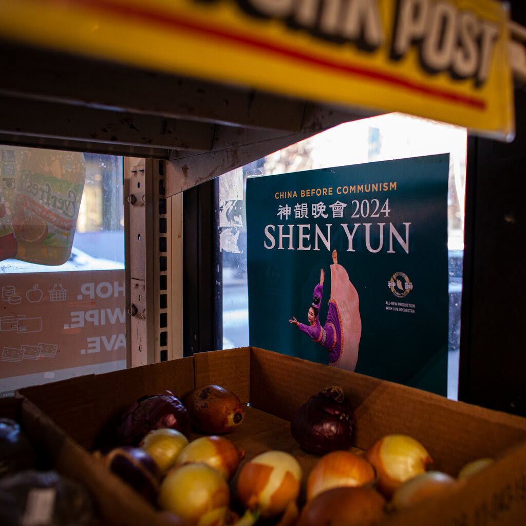 A sign for the dance group Shen Yun hangs in a window of a shop in New York City.