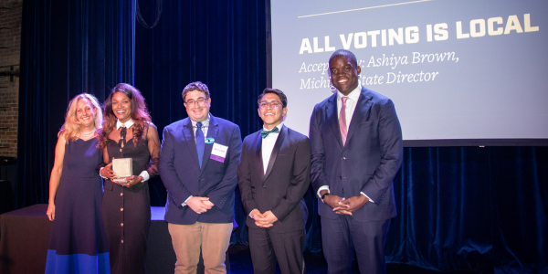 Michigan LCV Executive Director Lisa Wozniak on stage with All Voting Is Local's State Director Ashiya Brown, Michigan Senior Campaign Manager Ben Gardner, Michigan Senior Democracy Defense Manager Daniel Rivera, and Michigan LCV board member Justin Onwenu. 