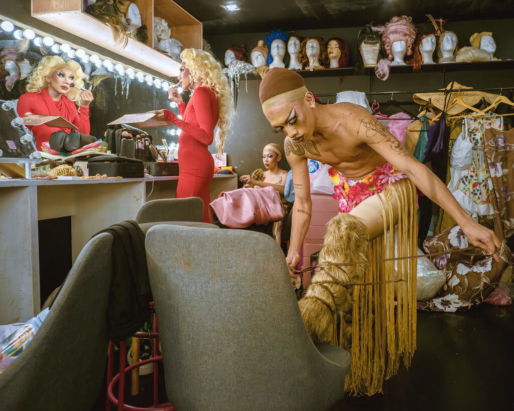 A performer in a dressing room putting on furry boots. 