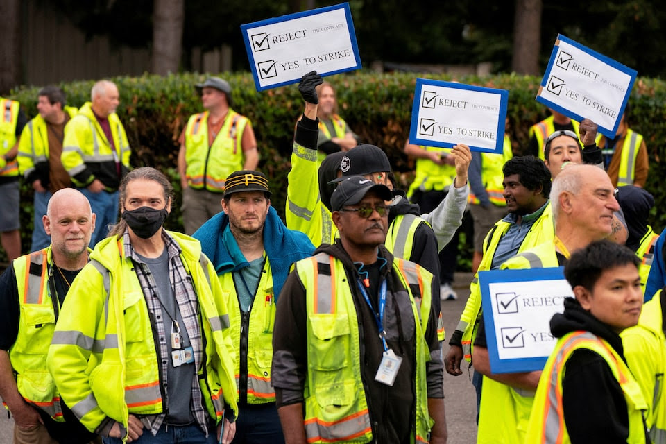 Boeing factory workers hold signs in Renton, Washington