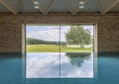 La gran ventana panorámica ofrece vistas espectaculares del paisaje a través de una piscina infinita.