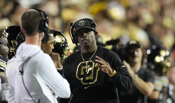 Colorado head coach Deion Sanders talks to assistant coaches in the second half of an NCAA college football game against Kansas State Saturday, Oct. 12, 2024, in Boulder, Colo. (AP Photo/David Zalubowski)