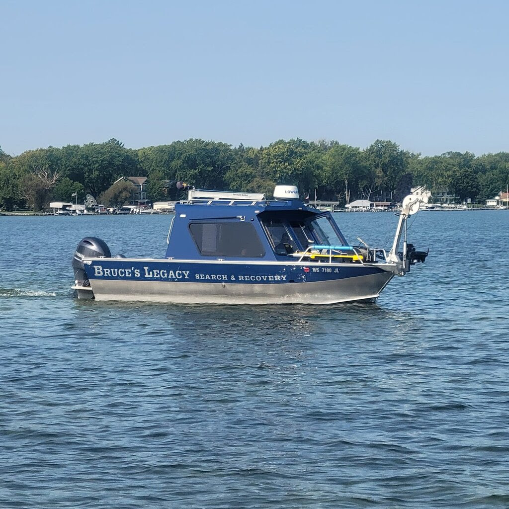 A blue boat on a lake that reads “Bruce’s Legacy Search & Recovery” along the side.