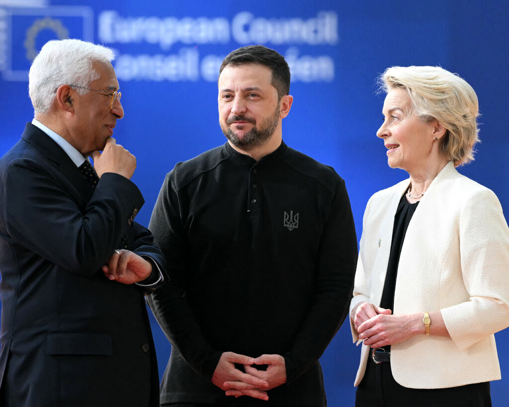 António Costa, Volodymyr Zelensky and Ursula von der Leyen talking against an blue backdrop.