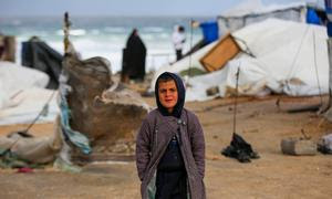 Un niño intenta mantenerse caliente con ropa de invierno mientras las tormentas azotan Gaza.