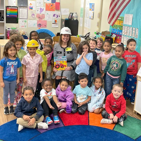 a photo of Chancellor Miller with a classroom of preschoolers posing for the camera